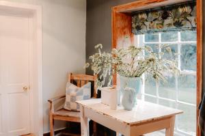 a room with a table and a vase of flowers at Fable Country Stay in Curryʼs Post +18 photos
