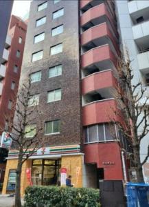 a tall red brick building with a man standing in front of it at 歌舞伎町704 in Tokyo