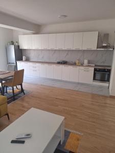 an empty kitchen with white cabinets and a table at Niko Fundali in Bitola