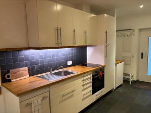 英格堡Genuine mountain holiday apartment in Engelberg的带白色橱柜和水槽的厨房