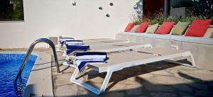 two chairs and a table next to a swimming pool at Villa Smoquizza in Smokvica