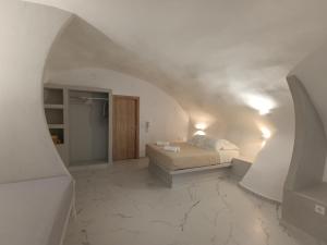 a bedroom with a bed in a white room at Santorini White Lotus in Perissa