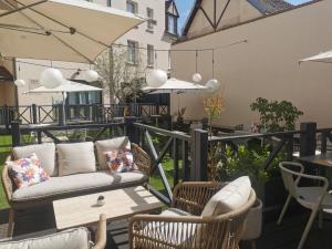 a patio with a couch and chairs and tables at Hôtel Le Normandy - Maison Tassoni in Vernon +72 photos