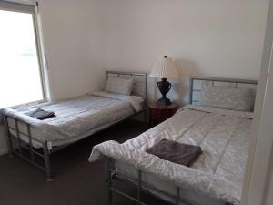 a bedroom with two beds and a lamp and a window at Buxton Countryside Home in Buxton