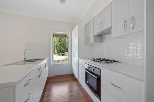 a white kitchen with a sink and a stove at Buxton Countryside Home in Buxton