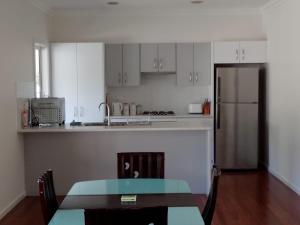 a kitchen with a table and a refrigerator at Buxton Countryside Home in Buxton