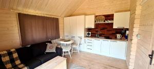 a living room with a couch and a kitchen at Cuda Wianki in Zdów