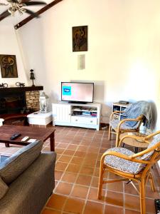 a living room with a couch and a tv at Entire Bungalow style villa in La Manga Club in Atamaría