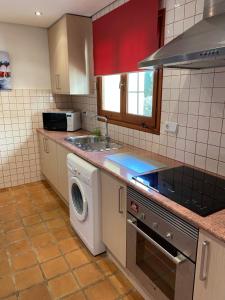 a kitchen with a sink and a washing machine at Entire Bungalow style villa in La Manga Club in Atamaría