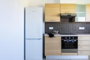 a kitchen with a white refrigerator and wooden cabinets at Penthouse Apartment with Amazing View in Kiti in Kiti +11 photos