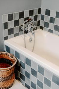 a bath tub with a faucet in a bathroom at Fable Country Stay in Curryʼs Post