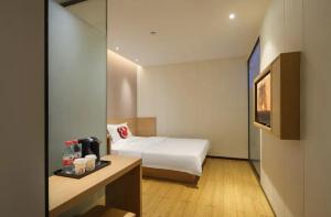 广州Locals Hotels Guangzhou Sports Center Linhe West Subway Station Branch的配有床和电视的酒店房间