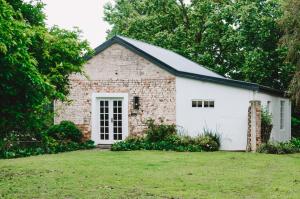 a brick house with a white garage at Fable Country Stay in Curryʼs Post