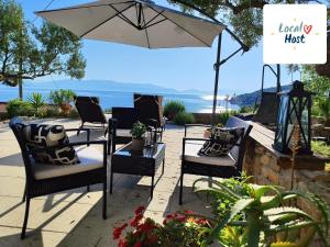 patio z krzesłami i stołem z parasolem w obiekcie Weekend house Olive garden w mieście Donje Selo na Šolti