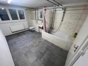 a bathroom with a tub and a toilet and a sink at Möblierte Studiowohnung 65 m2 Wohnfläche mit Kostenlosen Endreinigung in Fulenbach