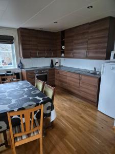 a kitchen with a table with chairs and a refrigerator at Roligheten hytte in Farsund
