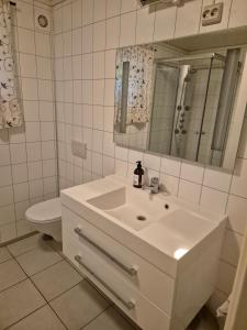 a white bathroom with a sink and a toilet at Roligheten hytte in Farsund +8 photos