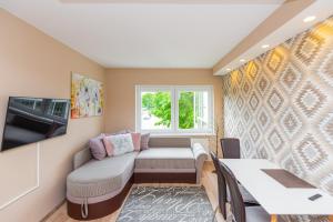 a small living room with a couch and a window at Vila Romantika in Palanga