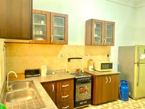 a kitchen with a sink and a stove top oven at Coral Place in Abeokuta