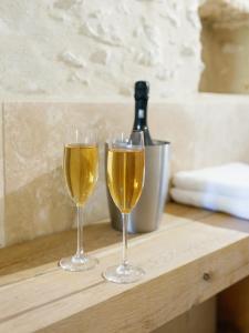 due bicchieri di vino appoggiati su un tavolo di legno di L’Oxalis villa, Sauna et Jaccuzi privatif a Bullion