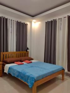 a bedroom with a bed with blue sheets and curtains at Michael's Apartment in Moalboal