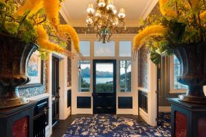 a hallway with a chandelier and two vases at Hulbert House Luxury Boutique Lodge Queenstown in Queenstown