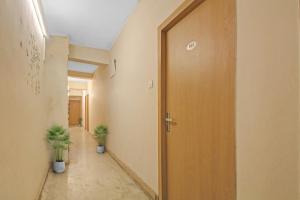 ĀlīpurHotel O The Jumbo Stay的门和两株植物的办公走廊