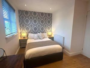 a bedroom with a bed with two lamps on two tables at Executive 1bd 1st floor flat in Caerleon