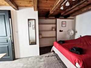 Un dormitorio con una cama roja y un espejo. en Duplex à inaugurer, en Florac