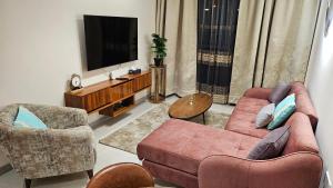 キガリにあるGreenland Executive Apartmentのリビングルーム(ソファ2台、テレビ付)