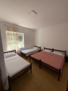 three beds in a room with a window at Apartments Lazo in Ulcinj
