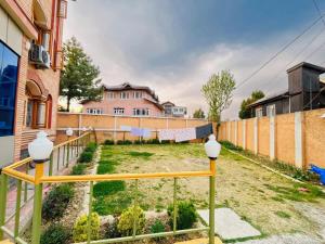 un cortile con recinzione e una casa di Bashaw Residency Top Rated In Srinagar Only 6 Kms from Srinagar International Airport And Only 5 Kms From Srinagar Railway Station a Srinagar