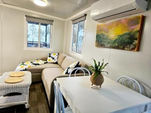 a living room with a couch and a table at Tiny Cottage by the Lake in Waranga