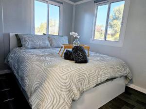 a bedroom with a bed with two bags on it at Tiny Cottage by the Lake in Waranga