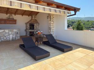 a patio with a table and chairs and a fireplace at Blue Seagull in Utjeha