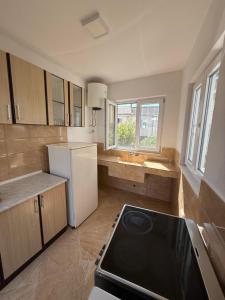 a kitchen with a white refrigerator and a stove at Apartments Lazo in Ulcinj