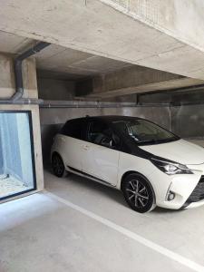 a white car parked in a parking garage at Luxe Neuf - Parking Privé Gratuit - 10mn Paris RER D - Lit 160X200 - Tout équipé - De 1 à 4 pers - Near Paris Brand New Apart with Secure Parking in Maisons-Alfort