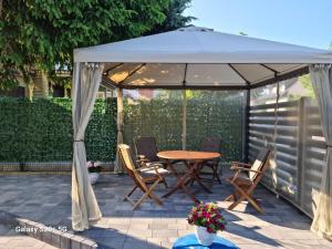 a gazebo with a table and chairs under it at Apartamenty Dana in Pustkowo