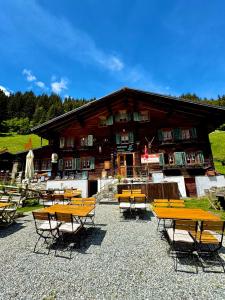 a group of tables and chairs in front of a building at Ustria Val Sumvitg in Surrein