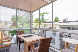 a room with a table and chairs and windows at Vila Romantika in Palanga