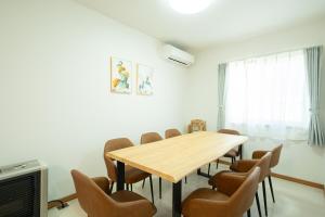 Un comedor con mesa y sillas de madera. en Kikusui House, en Sapporo