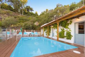 a swimming pool on a deck with chairs and a house at Casa Mica naturaleza y relax in Vega de San Mateo