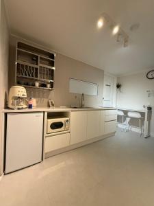a kitchen with white appliances and a table and chairs at Staymuk Seochon, Center of Seoul in Seoul