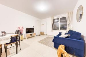 a living room with a blue couch and a table at Luxe Neuf - Parking Privé Gratuit - 10mn Paris RER D - Lit 160X200 - Tout équipé - De 1 à 4 pers - Near Paris Brand New Apart with Secure Parking in Maisons-Alfort
