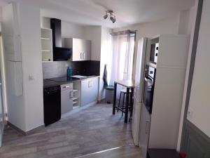 a kitchen with white cabinets and a table in it at Appartement Monton in Veyre-Monton