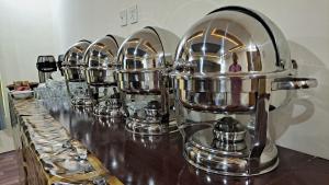 una fila di caffettiere d'argento allineate su un bancone di Adventure Sarai Hotel Skardu a Skardu Altre 24 foto