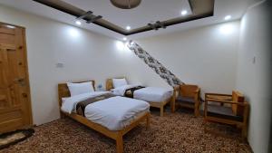 una camera con due letti e una scala di Adventure Sarai Hotel Skardu a Skardu