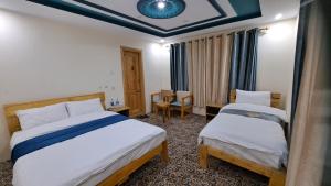 una camera con due letti e un soffitto blu di Adventure Sarai Hotel Skardu a Skardu