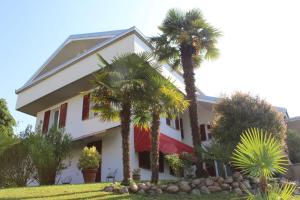 ein Haus mit Palmen davor in der Unterkunft BF SUITE Foresteria Bellusci in Rho