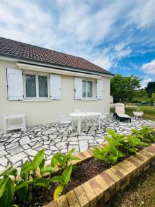 a patio with a table and chairs in front of a house at Maison située aux confins de la Vallée du Loir in Le Lude